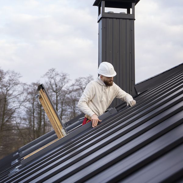 Ouvrier en intervention sur une toiture en zinc à joint debout, travaux de couverture et zinguerie Ouvrier en intervention sur une toiture en zinc à joint debout, travaux de couverture et zinguerie